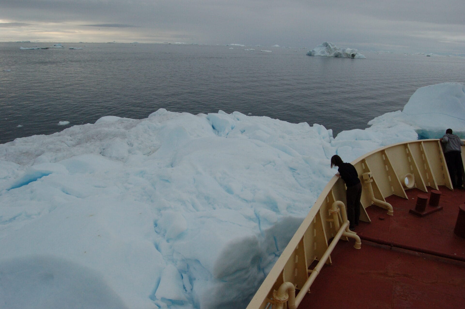 photograph of ship and iceberg