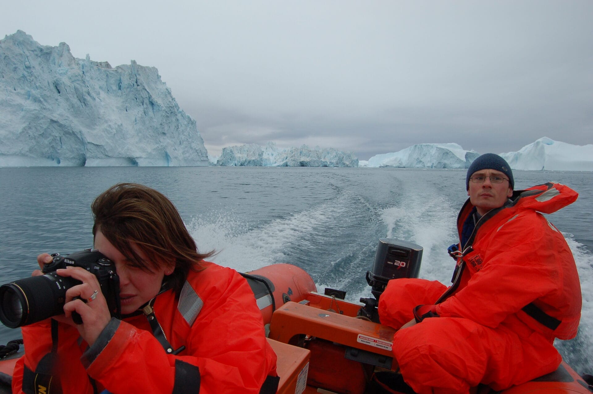 Photograph of the monitoring crew on a boat in the ocean surrounded by icebergs.