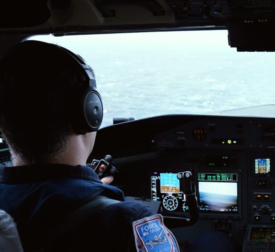 Pilot and copilot in cockpit of Dash 8-300 looking out the windscreen at the ocean