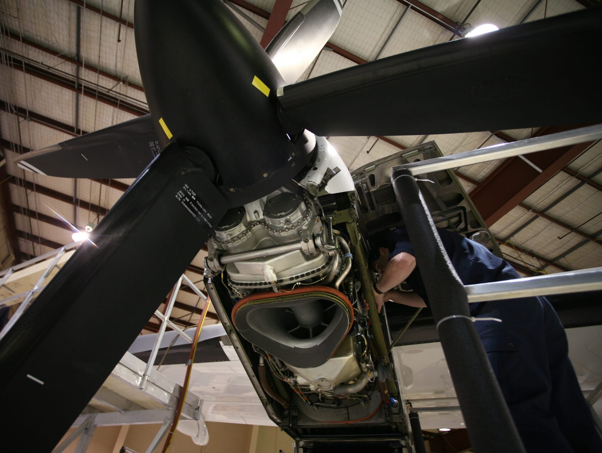 AME inspecting Dash 8 engine in hangar
